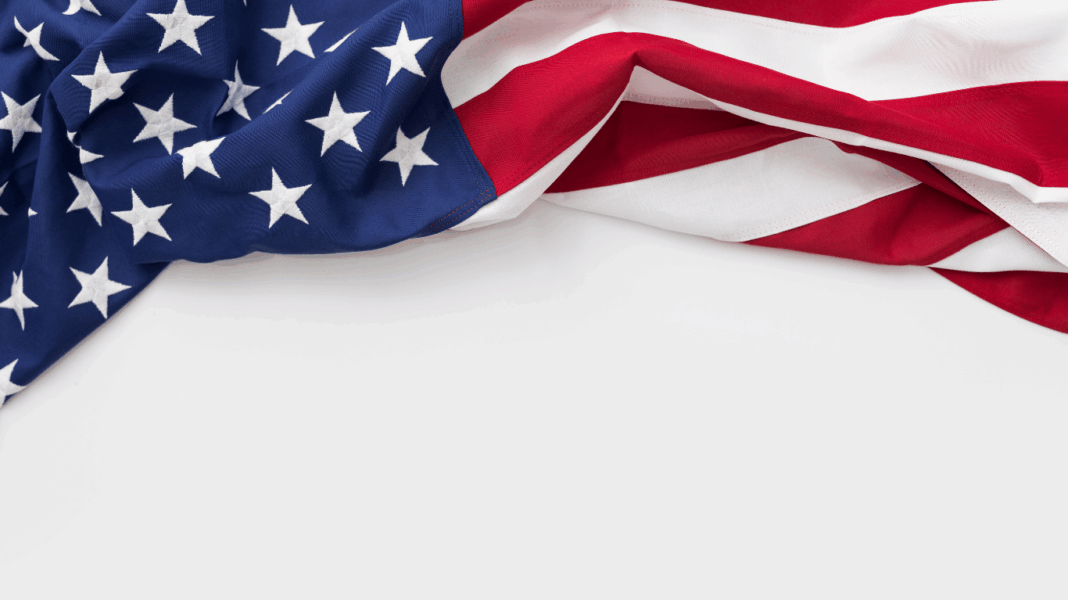 WSJ: Propast mezi růstem zisků firem a růstem mezd je v USA rekordní Partial view of a U.S. flag draped, showing blue field with white stars and red-and-white stripes on white background